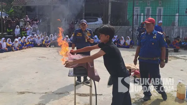 Salah satu pelajar mencoba simulasi kebakaran akibat kebocoran gas di SMP PGRI Bencoy, Kecamatan Cireunghas, Kabupaten Sukabumi, Kamis (17/7/2025). | Foto: Istimewa