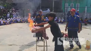 Salah satu pelajar mencoba simulasi kebakaran akibat kebocoran gas di SMP PGRI Bencoy, Kecamatan Cireunghas, Kabupaten Sukabumi, Kamis (17/7/2025). | Foto: Istimewa