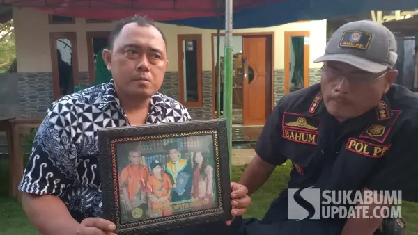 Aben saat memperlihatkan foto Adik iparnya, Deni Sugiarto saat diwisuda.(Sumber Foto: SU/Ragil Gilang)