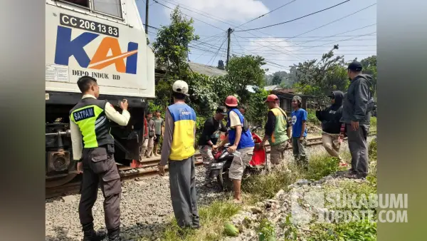 Warga bersama petugas keamanan mengevakuasi sepeda motor Honda Scoopy yang terseret kereta di perlintasan tanpa palang pintu di Parungkuda Sukabumi, Kamis (24/7/2025). (Sumber Foto: SU/Ibnu)