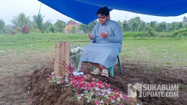 Putra sulung Yuswandi berdoa di pusara ayahnya. Yuswandi meninggal dunia di Pos 5 Gunung Slamet saat mendaki bersama istrinya. (Sumber Foto: SU/Ibnu)