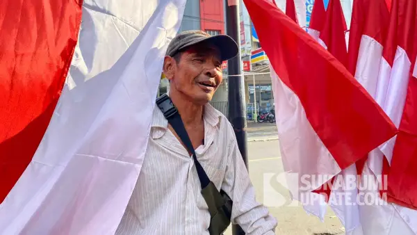 Apai Kurniawan (58 tahun) pedagang bendera musiman asal Garut, Jawa Barat, berjualan di Jalan Bhayangkara, Kota Sukabumi, Selasa (29/7/2025). | Foto: SU/Asep Awaludin