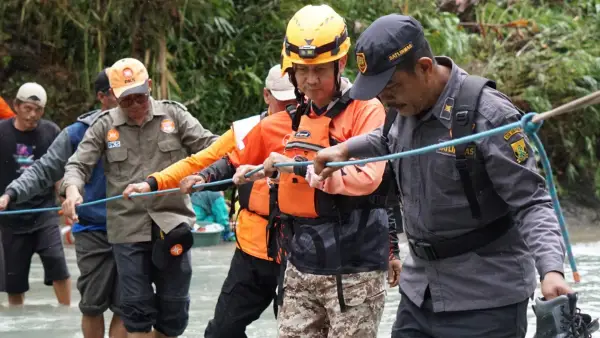 Anggota Komisi IV DPR RI Fraksi PKS drh Slamet (kedua dari kanan) melintasi sungai di salah satu wilayah terdampak bencana di Kabupaten Sukabumi. | Foto: Istimewa