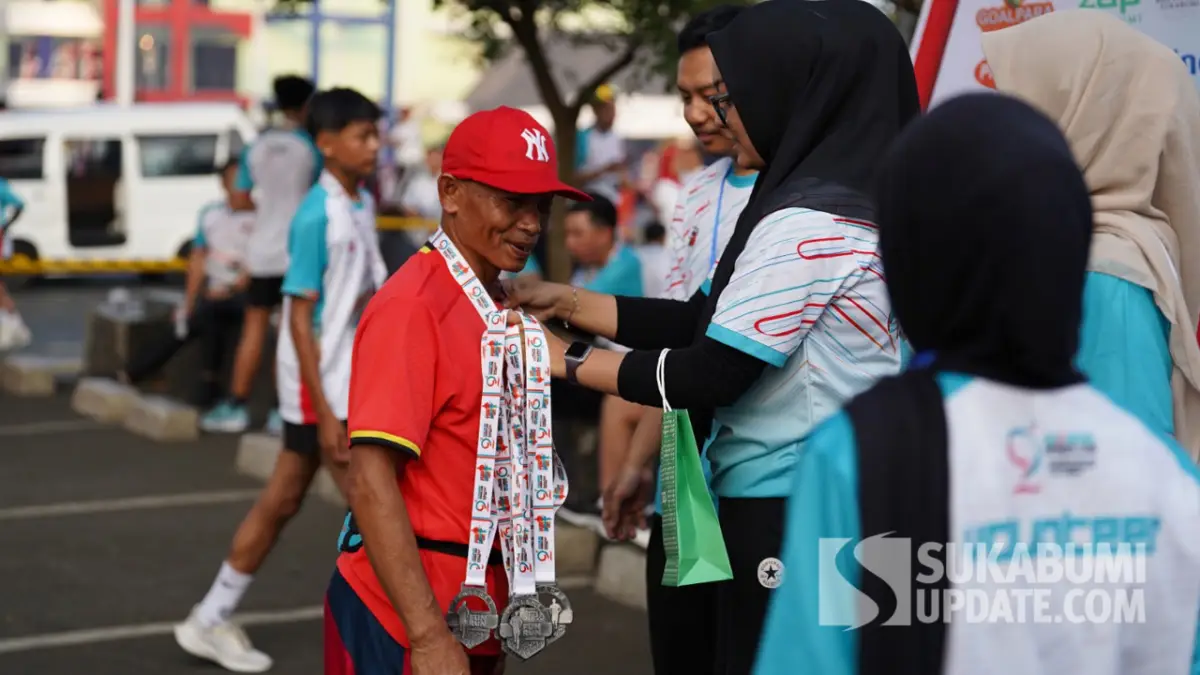 Mulyadi saat dikalungkan medali oleh panitia usai menyelesaikan lari di event Sukabumi Global FUN RUN 2025.