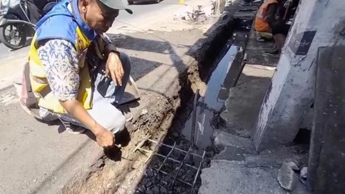 Pengawas lapangan dari Kementerian PUPR PPK 2.1 Jawa Barat, Agus Warso memperlihatkan bagian drainase jalan nasional di Cicurug Sukabumi yang tertutup cor beton permanen.