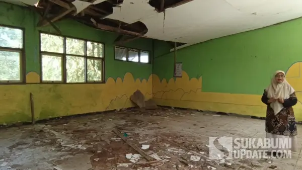 Kepala SDN Gunung Batu Sukabumi, Ami Kusmaeni, menunjukkan ruang kelas yang rusak parah dengan atap dan plafon nyaris ambruk, Jumat (8/8/2025). (Sumber Foto: SU/Asep Awaludin)
