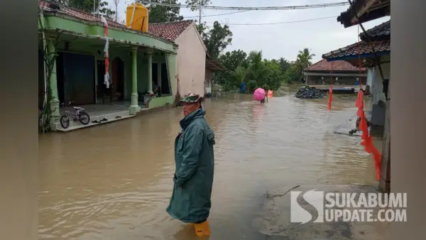 Petugas BPBD Kabupaten Sukabumi memantau kondisi banjir yang menggenangi area permukiman di Kecamatan Tegalbuleud. (Sumber Foto: Dok. P2BK Tegalbuleud)