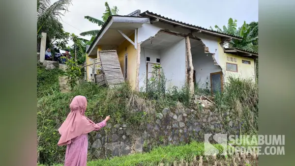 Atin (54), janda asal Cibeureum Kota Sukabumi, menunjuk rumahnya yang ambruk diterjang banjir pada November 2024. Setahun berlalu, rumah tersebut belum mendapat perbaikan. (Sumber Foto: SU/Asep Awaludin)