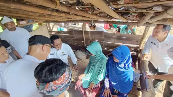 Bupati Sukabumi Asep Japar saat berbincang dengan Etin dan ibunya. Kedua warga Desa Loji itu diketahui terpaksa tinggal di sebuah kandang domba karena rumah mereka nyaris roboh dan tidak layak huni. (Sumber Foto: SU/Ilyas)