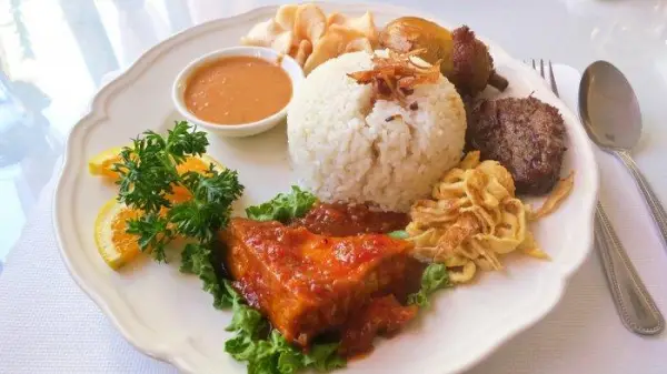 Tampilan nasi uduk lengkap dengan menu pelengkap seperti, telur iris, ayam goreng, tahu, sambal kacang, kerupuk serta taburan bawang goreng (Sumber : X/@wargatudum)