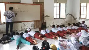 Sebanyak 23 siswa kelas V SDN Cipaku Sukabumi harus belajar di lantai musala dengan posisi tengkurap karena ruang kelas mereka rusak. (Sumber Foto: Istimewa)