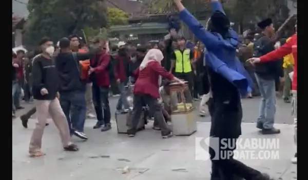 Momen saat Riska Mahasiswi Nusa Putra University lindungi pedagang kue ape di tengah kericuhan demonstrasi di depan gedung DPRD Kota Sukabumi. (Sumber : Tangkapan layar video/Istimewa)