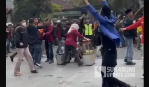 Momen saat Riska Mahasiswi Nusa Putra University lindungi pedagang kue ape di tengah kericuhan demonstrasi di depan gedung DPRD Kota Sukabumi. (Sumber : Tangkapan layar video/Istimewa)