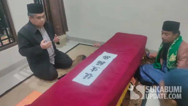 Plt Kepala Disnakertrans Kabupaten Sukabumi, Jujun Juaeni memanjatkan doa di samping jenazah Heri Wibawa, PMI asal Cikidang yang meninggal dunia di Korea Selatan. (Sumber Foto: Istimewa)