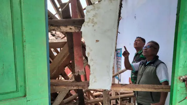 Kepala Desa Bojongjengkol, Nirwana saat mengecek kondisi ruangan kantor guru SDN 1 Bojongjengkol Sukabumi yang ambruk. (Sumber Foto: Istimewa)