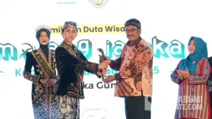 Bupati Asep Japar saat menyerahkan lencana simbolis kepada Mojang Jajaka terpilih. (Sumber: Dok Dispar)