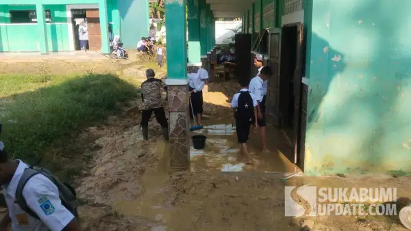 Guru, murid dan warga gotong royong bersihkan lantai kelas SMPN 2 Warungkiara Sukabumi yang masih terendam lumpur. (Sumber Foto: Istimewa)