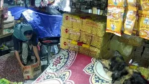 Rekaman CCTV menampilkan seorang pria berpenutup kepala tengah mencuri kardus berisi dagangan di salah satu kios Pasar Palabuhanratu Sukabumi. (Sumber Foto: Tangkapan layar video CCTV)