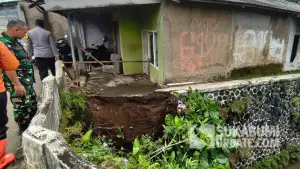 Petugas gabungan meninjau rumah milik Buhori (76 tahun) di Kampung Nagrak Kaler, Desa Nagrak, Kecamatan Cisaat, Kabupaten Sukabumi, yang terancam amblas ke Sungai Cikupa akibat longsor pada Rabu (12/11/2025). (Sumber : P2BK Cisaat)
