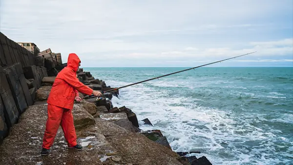 Ilustrasi - Awas Bahaya Saat Mancing di Pinggir Laut! Ini Perlengkapan dan Tips Aman. (Sumber : Freepik.com/@mego-studio).