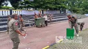 Meskipun baru menyelesaikan rangkaian pengamanan sejak pagi hari, para personel Satpol PP Kabupaten Sukabumi tetap sigap membersihkan sampah yang berserakan di sekitar lokasi acara. (Sumber Foto: SU/Ilyas)