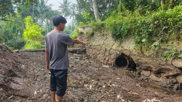 Warga setempat saat menunjukan saluran irigasi yang kering akibat jebolnya bendungan Cidadap di Kebonpedes, Kabupaten Sukabumi. (Sumber: Istimewa)