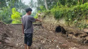 Warga setempat saat menunjukan saluran irigasi yang kering akibat jebolnya bendungan Cidadap di Kebonpedes, Kabupaten Sukabumi. (Sumber: Istimewa)