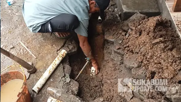 Petugas dari Perumdam TJM Cabang Parungkuda Sukabumi saat memperbaiki kebocoran pipa di Desa Sundawenang. (Sumber : SU/Ibnu Sanubari).
