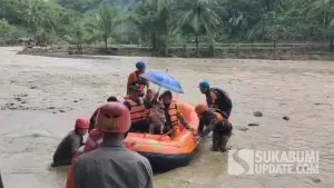 Kapolsek SImpenan, AKP Bayu Sunarti terlihat menggendong bayi 8 bulan ketika menyeberangi sungai Cidadap menggunakan perahu karet. Kamiis (18/12/2025). (Sumber: SU/Ilyas Supendi)