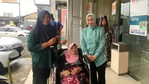 Pendamping PKH mendampingi KPM lansia disabilitas saat pengurusan KKS di Kantor BNI Pangleseran, Kabupaten Sukabumi. (Sumber Foto: Istimewa)