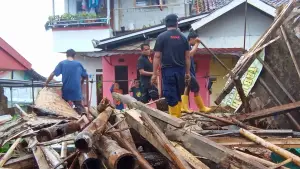 Petugas BPBD bersama warga membersihkan puing-puing rumah semi permanen yang ambruk akibat cuaca ekstrem di Gang Gelatik 2, Kelurahan Karamat, Kecamatan Gunungpuyuh, Kota Sukabumi, Jumat (19/12/2025). (Sumber Foto: Istimewa)