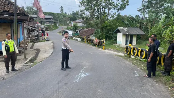 Petugas kepolisian saat olah TKP kecelakaan lalu lintas antara sepeda motor dan kendaraan Isuzu Box di Jalan Raya Jayanegara, Desa Kabandungan, Kecamatan Kabandungan, Kabupaten Sukabumi, Senin (22/12/2025). (Sumber : Polisi)