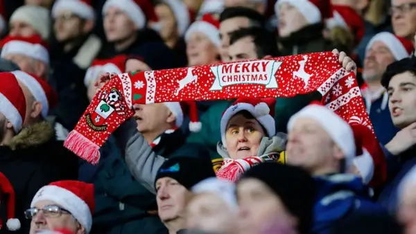 Seorang nenek membentangkan syal dari klub Southampton dengan bertuliskan selamat natal di salah satu tribun St Marys (Sumber: web/bbc.co.uk)