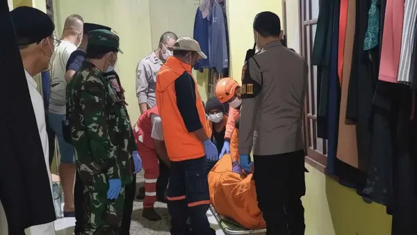Petugas gabungan mengevakuasi jenazah pria paruh baya yang ditemukan meninggal dunia di kamar kosnya di Kelurahan Tipar, Kecamatan Citamiang, Kota Sukabumi, Jumat (26/12/2025) malam. (Sumber Foto: Istimewa)