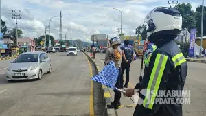 Petugas kepolisian saat rekayasa lalu lintas sistem satu arah (one way) di kawasan Simpang Tiga Ratu hingga Exit Tol Parungkuda, Sabtu (27/12/2025) sore, untuk mengurai kepadatan arus kendaraan. (Sumber : SU/Ibnu Sanubari).