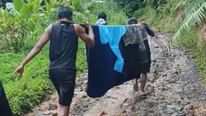 Ibu pasca melahirkan terpaksa ditandu ke Puskesmas karena kondisi jalan yang tidak dapat dilalui Ambulans di Desa Mangunjaya, Kecamatan Waluran, kabupaten Sukabumi. Kamis (1/1/2026). (Sumber: Video tangkapan layar warga)