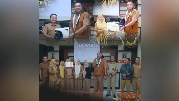 Kepala Bapenda Kabupaten Sukabumi Herdy Somantri  memberikan piagam penghargaan kepada sejumlah pegawai yang menunjukkan performa luar biasa sepanjang tahun 2025. (Sumber : IG Bapenda Kabupaten Sukabumi)