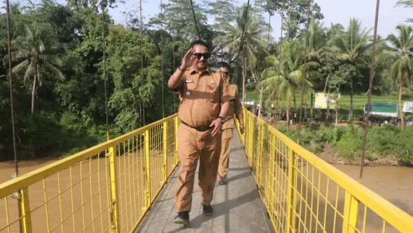 Bupati Sukabumi, Asep Japar saat melintasi Jembatan Gantung Leuwi reuming di Kecamatan Kalibunder yang baru diresmikan. Senin (26/1/2026). (Sumber: Dokpim)