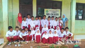 Para siswa dan guru saat berfoto bersama di depan gedung sekolah MI Swasta Cicayur, Desa Sukajaya, Kecamatan Pabuaran, Kabupaten Sukabumi, (Sumber: SU/Ragil Gilang)