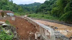 Bangunan tembok beton yang berdiri di aliran Sungai Ciseureuh, Desa Sangrawayang, Kecamatan Simpenan, Kabupaten Sukabumi. Menurut warga, tembok beton tersebut sejatinya adalah Tembok Penahan Tanah (TPT). (Sumber Foto: SU/Ilyas)
