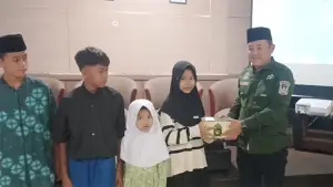 Kepala Dinas Kesehatan Kabupaten Sukabumi H. Masykur Alawi saat memberikan bingkisan kepada anak-anak yang hadir di lokasi. (Sumber : Istimewa.).