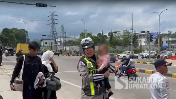 Polwan Polres Sukabumi saat menggendong bayi 11 bulan yang terjebak cuaca panas akibat sistem One Way Arus Balik Lebaran 2026 (Sumber : SU/Turangga Anom).