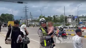 Polwan Polres Sukabumi saat menggendong bayi 11 bulan yang terjebak cuaca panas akibat sistem One Way Arus Balik Lebaran 2026 (Sumber : SU/Turangga Anom).