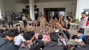 Ketua DPRD Kabupaten Sukabumi, Budi Azhar Mutawali saat mendegarkan aspirasi dari Aliansi Kaum Muda Sukabumi Melawan di halaman Gedung DPRD Kabupaten Sukabumi, Senin (6/4/2026). (Sumber : SU/Ilyas).