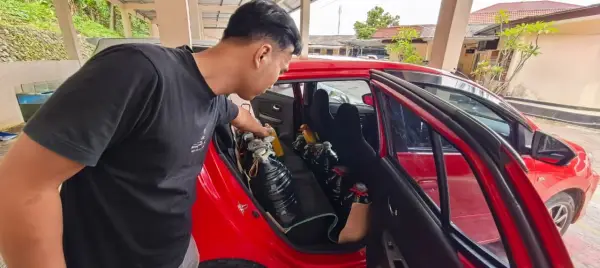 Petugas Unit Tipidter Sat Reskrim Polres Sukabumi saat menunjukan barang bukti puluhan galon dan jerigen yang digunakan pelaku untuk timbun Pertalite. (Sumber Foto: Dok. Polres Sukabumi)