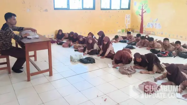 Puluhan siswa kelas III SDN 2 Cibenda Sukabumi saat mengikuti materi pelajaran dengan cara duduk di lantai ruang kelas yang baru direhabilitasi. (Sumber Foto: SU/Ragil Gilang)