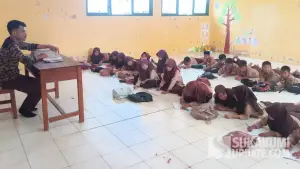 Puluhan siswa kelas III SDN 2 Cibenda Sukabumi saat mengikuti materi pelajaran dengan cara duduk di lantai ruang kelas yang baru direhabilitasi. (Sumber Foto: SU/Ragil Gilang)