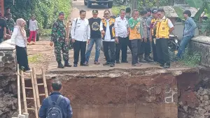 Kadis PU Kabupaten Sukabumi, Uus Firdaus saat meninjau langsung Jembatan Linggamanik yang ambruk diterjang banjir. Rabu (22/4/2026). (Sumber: Istimewa)
