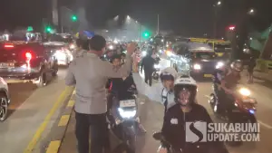 Seorang petugas kepolisian saat menyapa bobotoh Pesib yang berkonvoi di kawasan exit tol Parungkuda, Kabupaten Sukabumi | Foto : Ibnu Sanubari