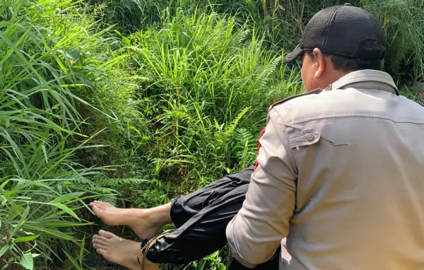 Polisi saat mengevakuasi wanita di sungai Kabandungan Sukabumi. (Sumber: Istimewa)